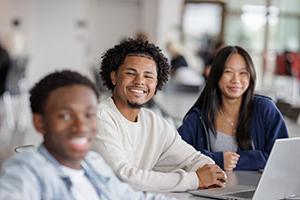 Male and female students smiling in cafe